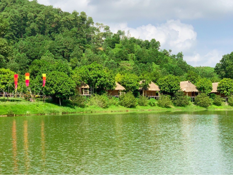 Hệ thống nhà sàn bên rìa hồ nước và rặng cây xanh tại thung lũng Bản Xôi là địa điểm du lịch gần Hà Nội được nhiều người yêu thích.